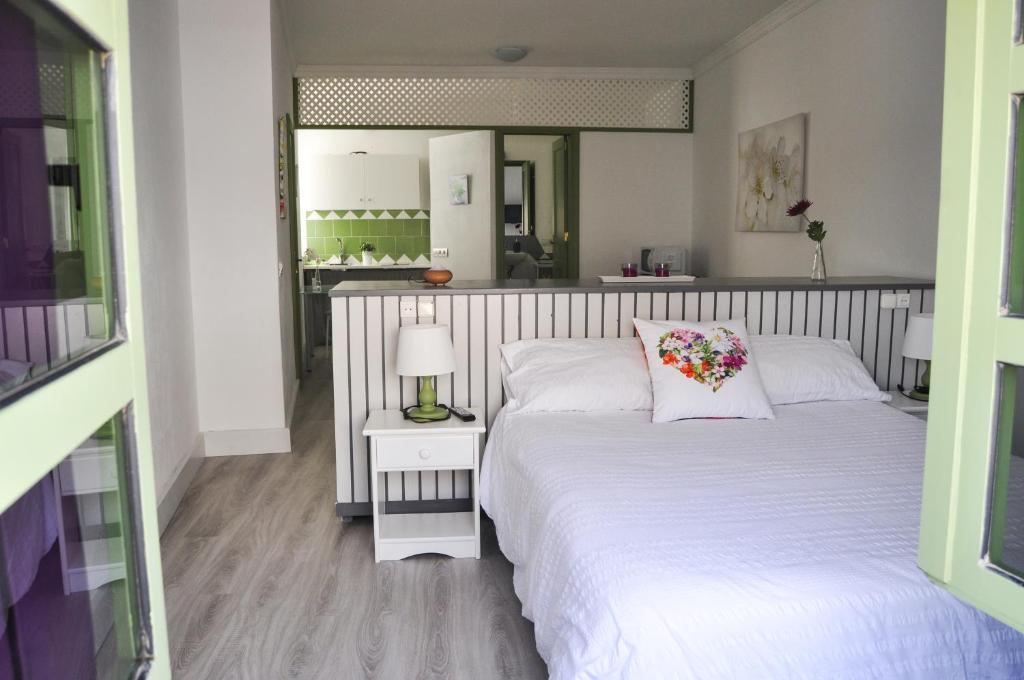1 dormitorio con cama blanca y espejo en Casa Villalba, en San Bartolomé