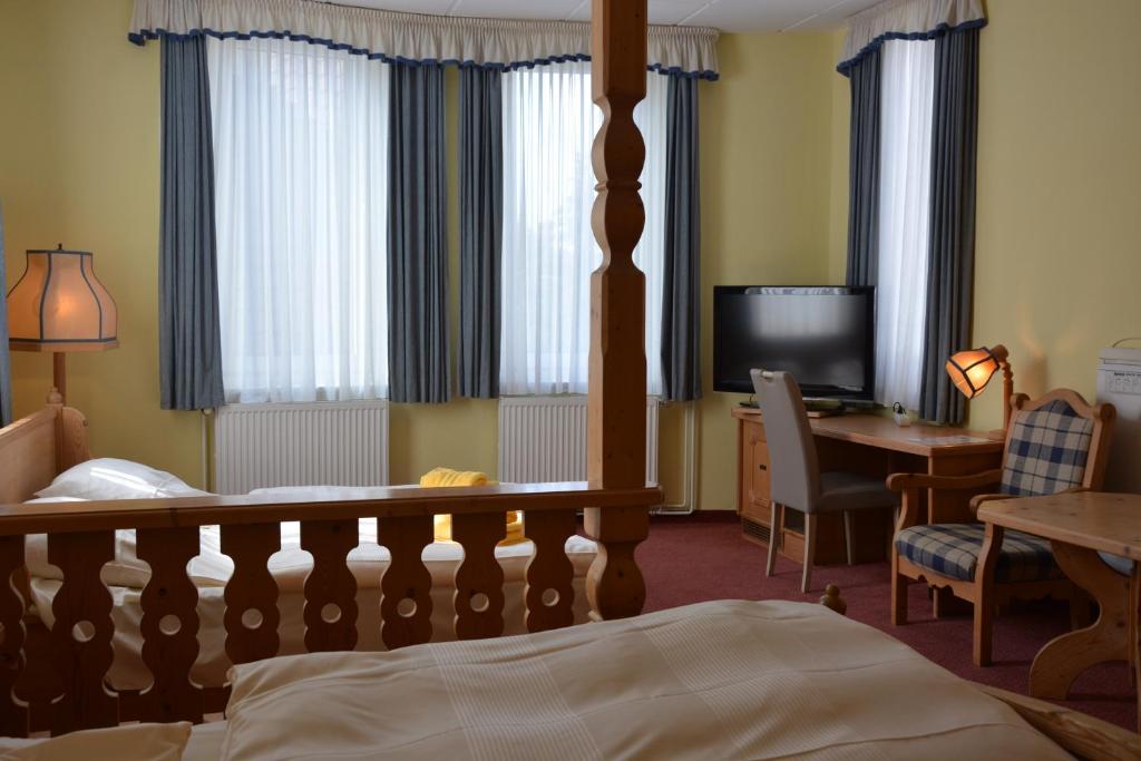 Dormitorio con cama, escritorio y TV en Hotel Meyn en Soltau