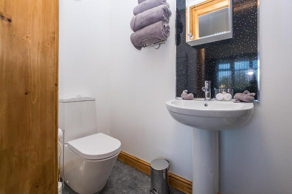 a white bathroom with a toilet and a sink at Lazy Days in Whitby
