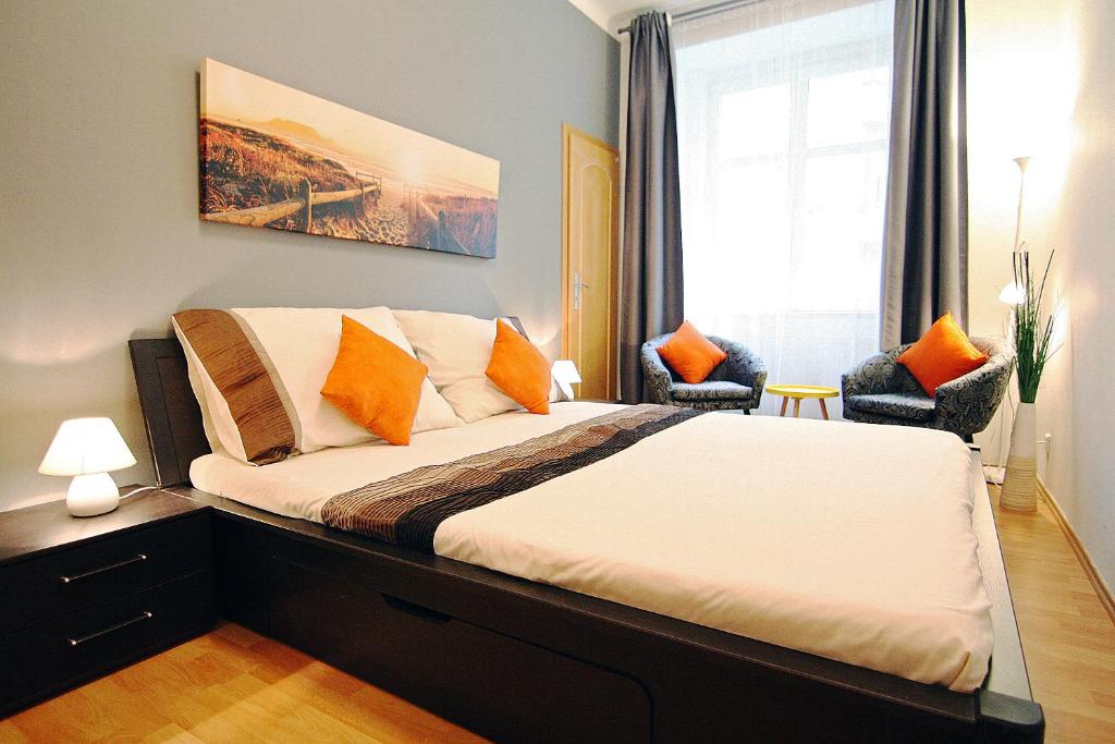プラハにあるStyle Apartmentのベッドルーム1室(大型ベッド1台、オレンジ色の枕付)