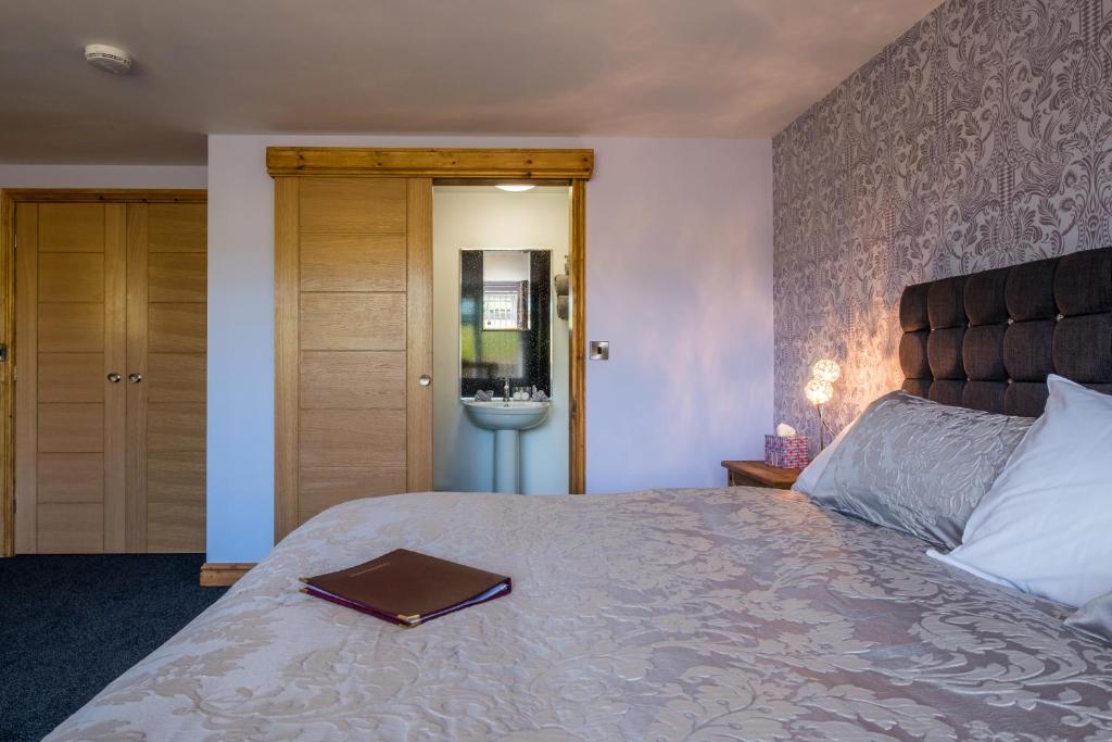 a bedroom with a bed with a book on it at Lazy Days in Whitby
