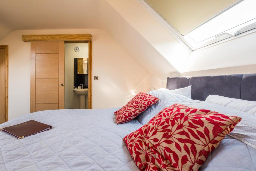 a bedroom with a bed with red pillows on it at Lazy Days in Whitby