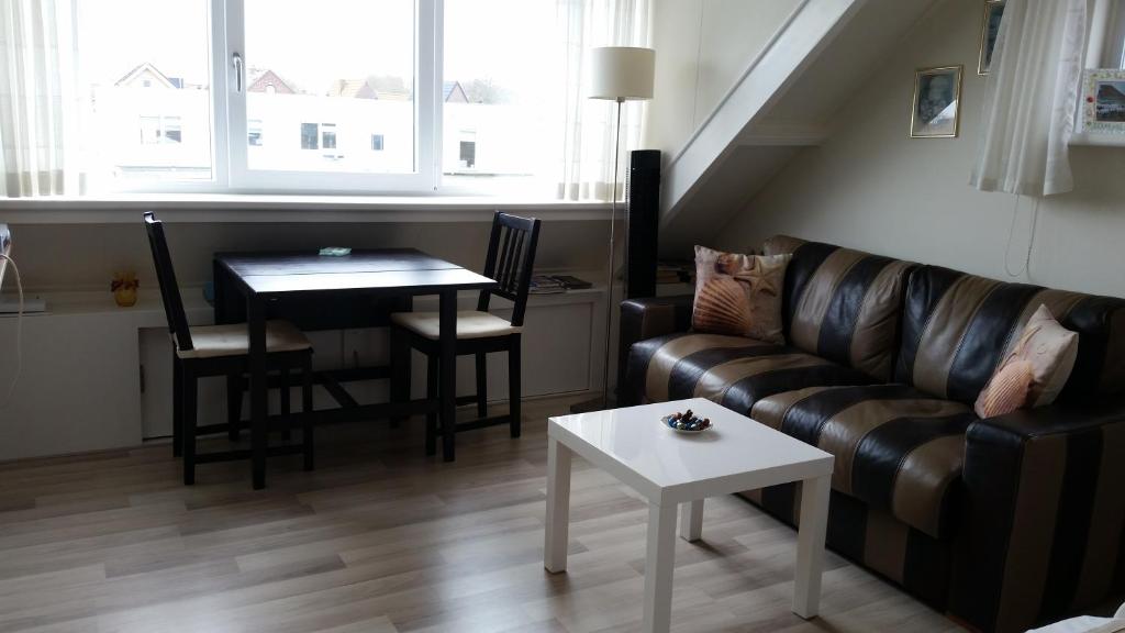 a living room with a couch and a table at Homestay Texel in Den Burg