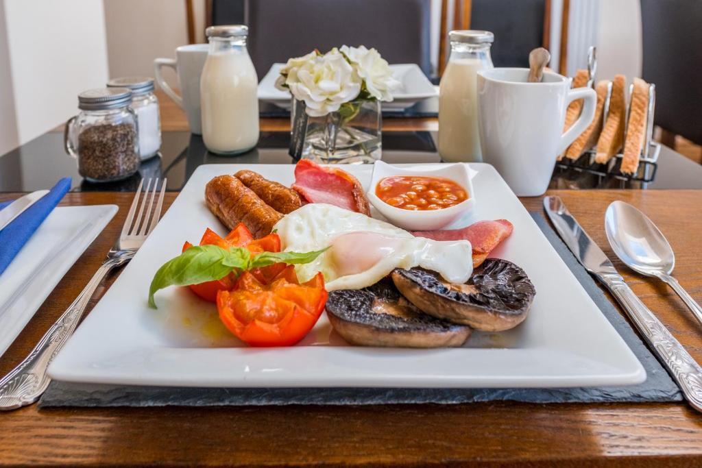 a plate of food with eggs sausage and vegetables on a table at Lazy Days in Whitby