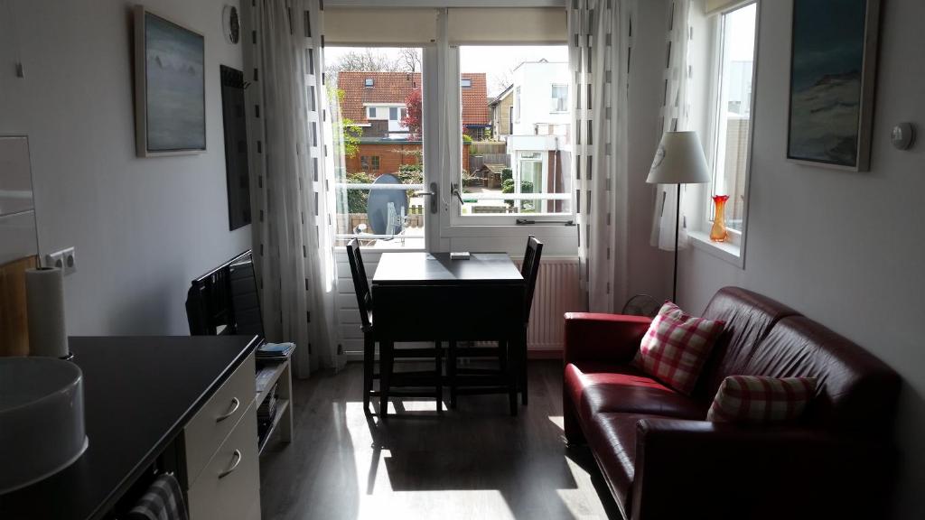 uma sala de estar com um sofá e uma mesa em Homestay Bij Aelita em Den Burg