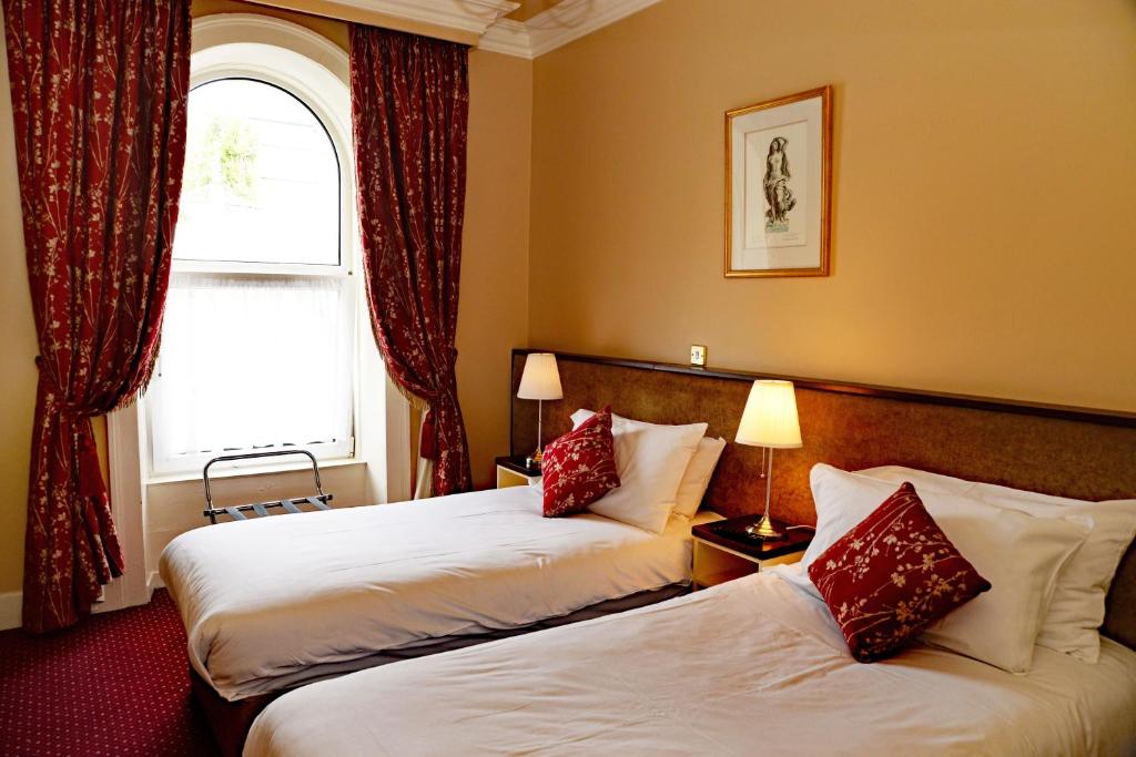 a hotel room with two beds and a window at Gabriel House Guesthouse in Cork