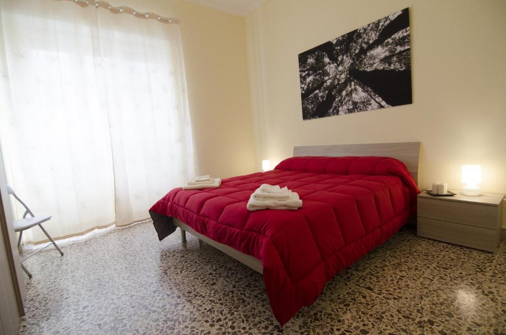 een slaapkamer met een rood bed en een rode deken bij Efesto Bed & Breakfast in Catania