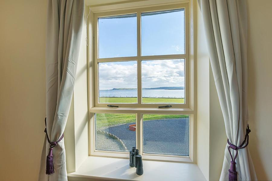 una ventana en una habitación con vistas al océano en The Moat on the Greenway en Dungarvan