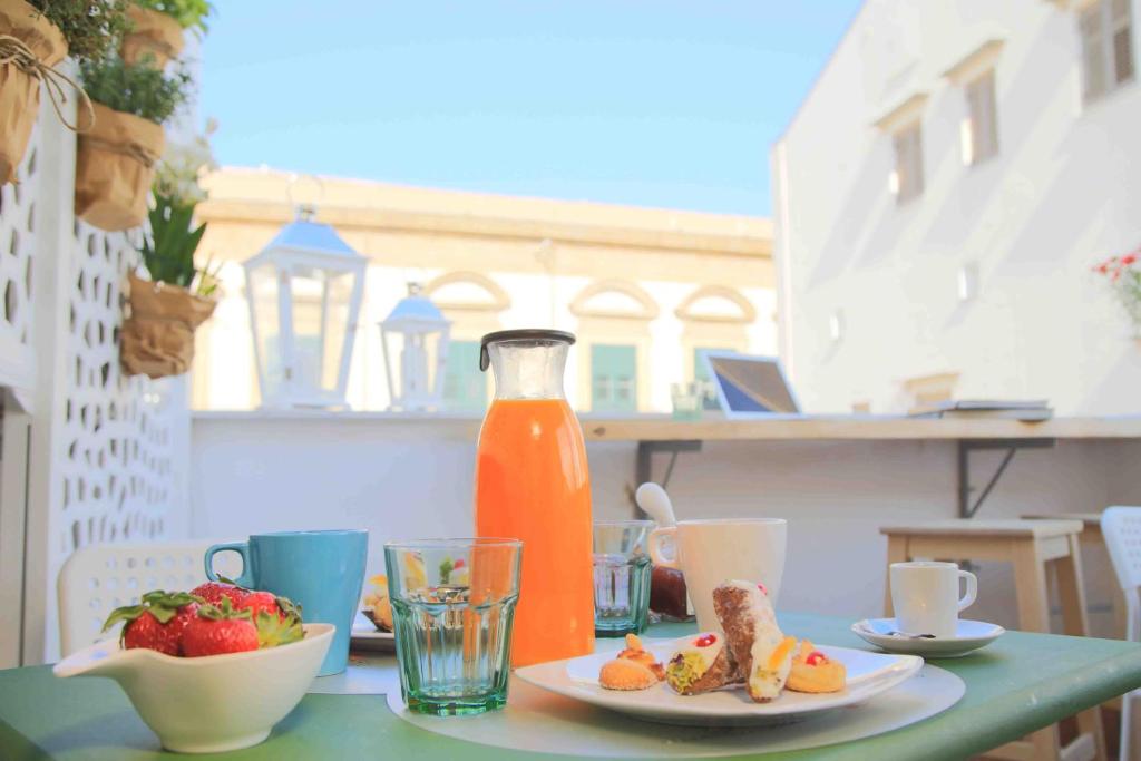 a table with plates of food and a bottle of orange juice at Jardin De France in Palermo