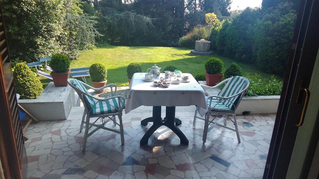 una mesa y sillas con un set de té en un patio en B&B La Villa Mediterranea en Passirano