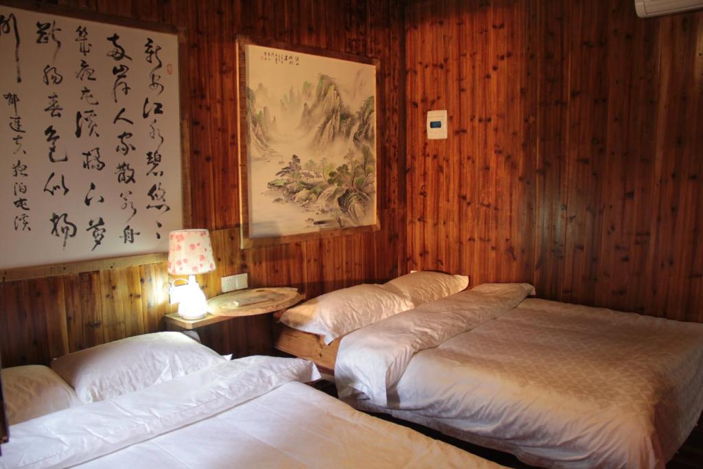 3 camas en una habitación con paneles de madera en Xishan Wutong Qinyuan (Free Pick up Service), en Huangshan