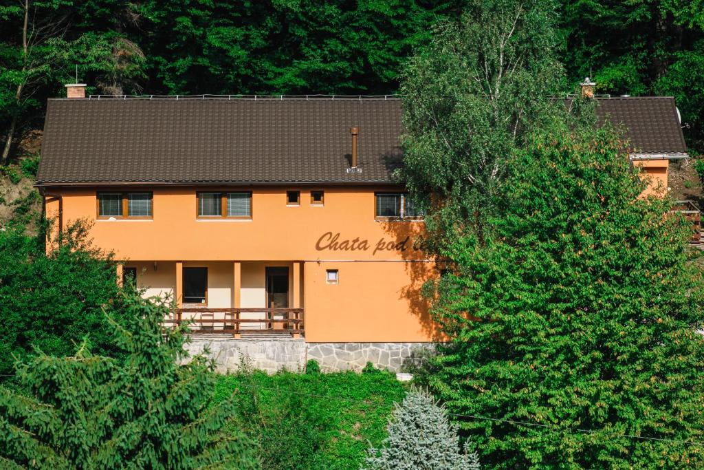 a large orange building in the middle of trees at Chata pod lesom in Drienica