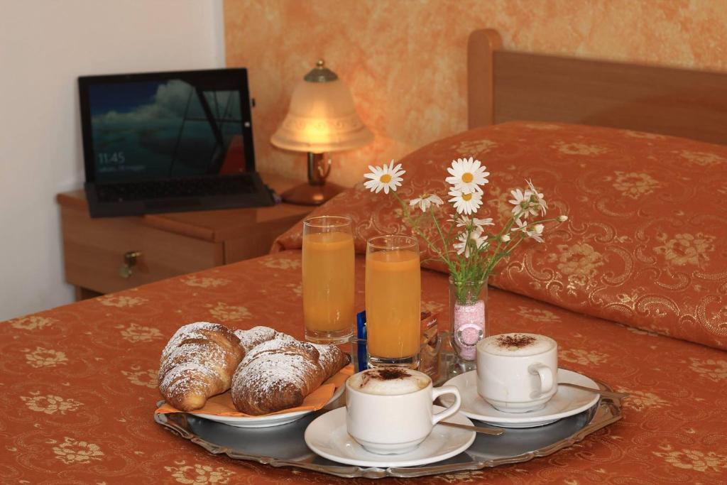 una mesa con una bandeja de bollería y dos tazas de zumo de naranja en Camere Santa Margherita, en Santa Margherita-Sant'Alessio Siculo