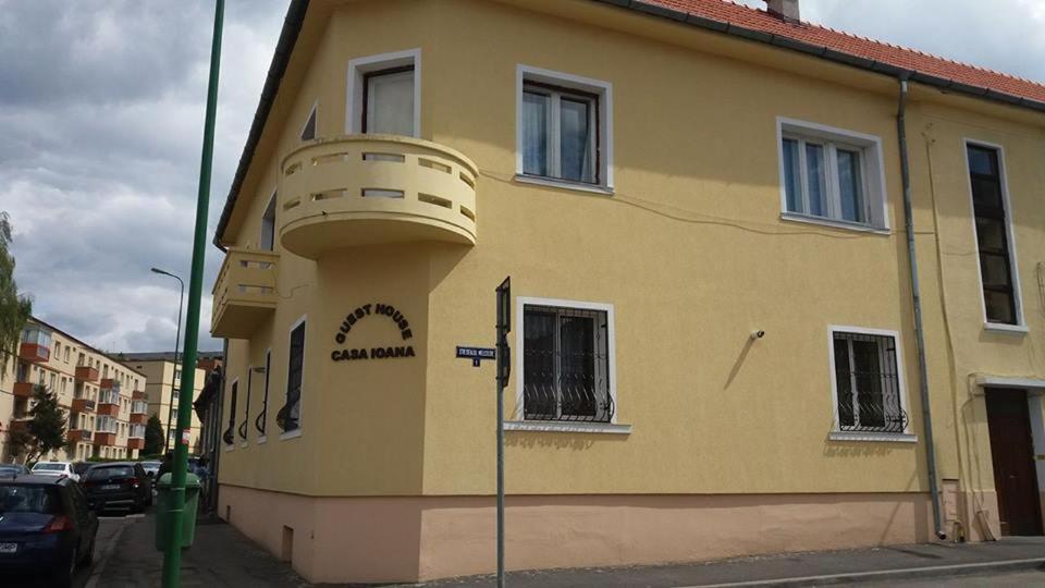 ein gelbes Gebäude mit einem Balkon an der Seite in der Unterkunft Villa Casa Ioana in Braşov