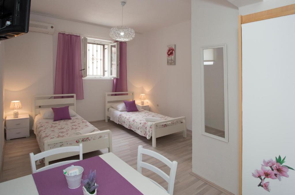 um pequeno quarto com duas camas e uma mesa em Summer Bay Apartments em Split