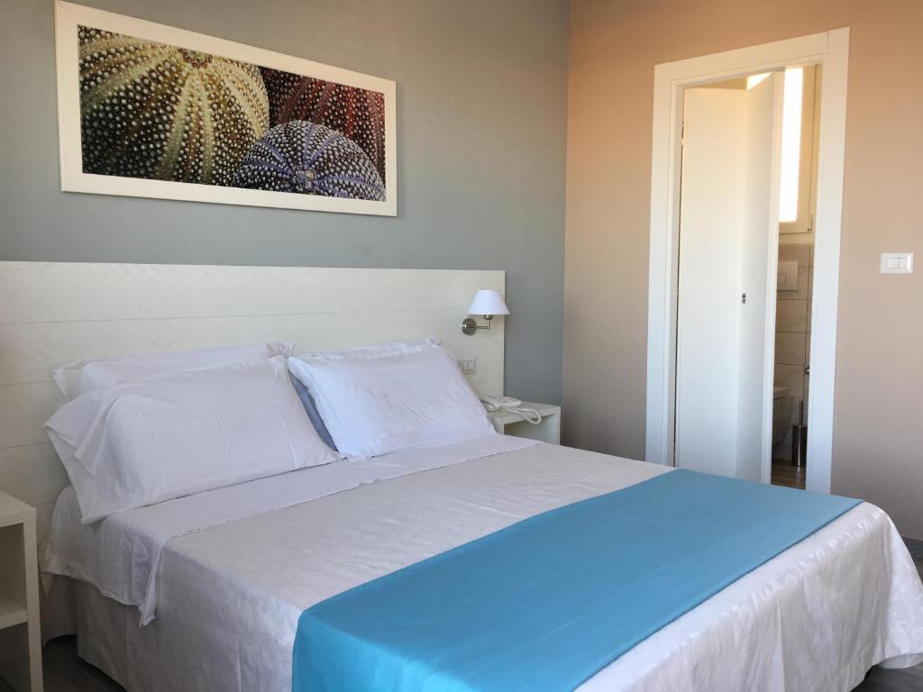 A bed or beds in a room at Le Anfore Hotel - Lampedusa