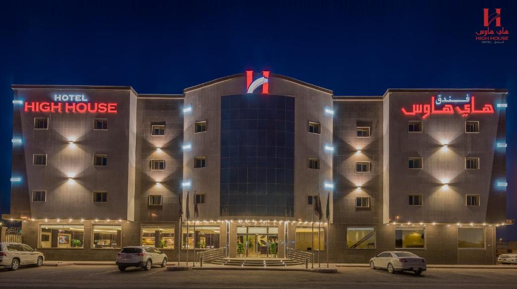 a hotel with cars parked in front of a building at High House in Sharurah