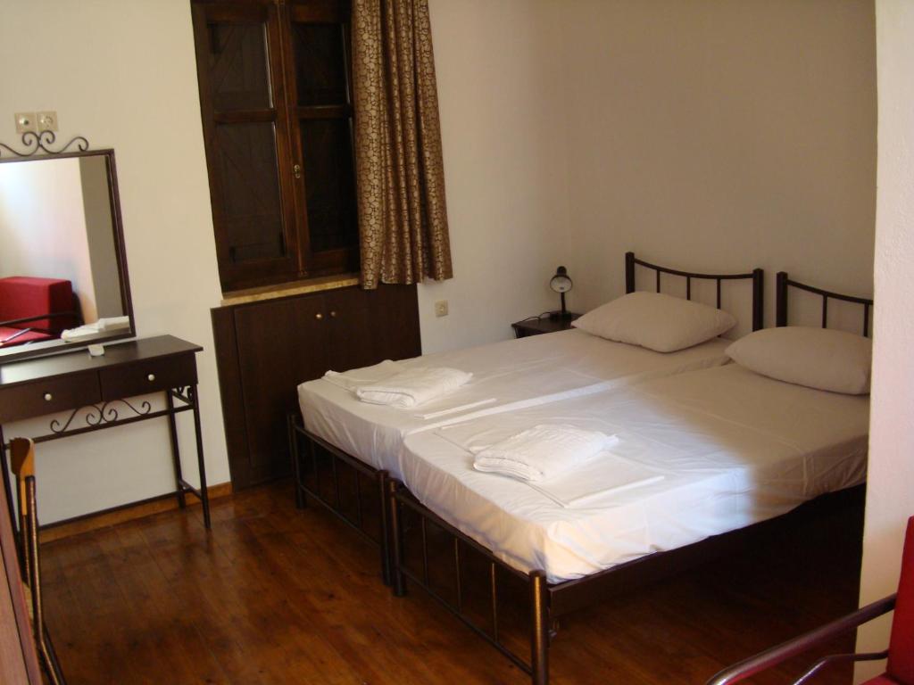 a bedroom with a bed with white sheets and a mirror at Old Town Apartments in Chania