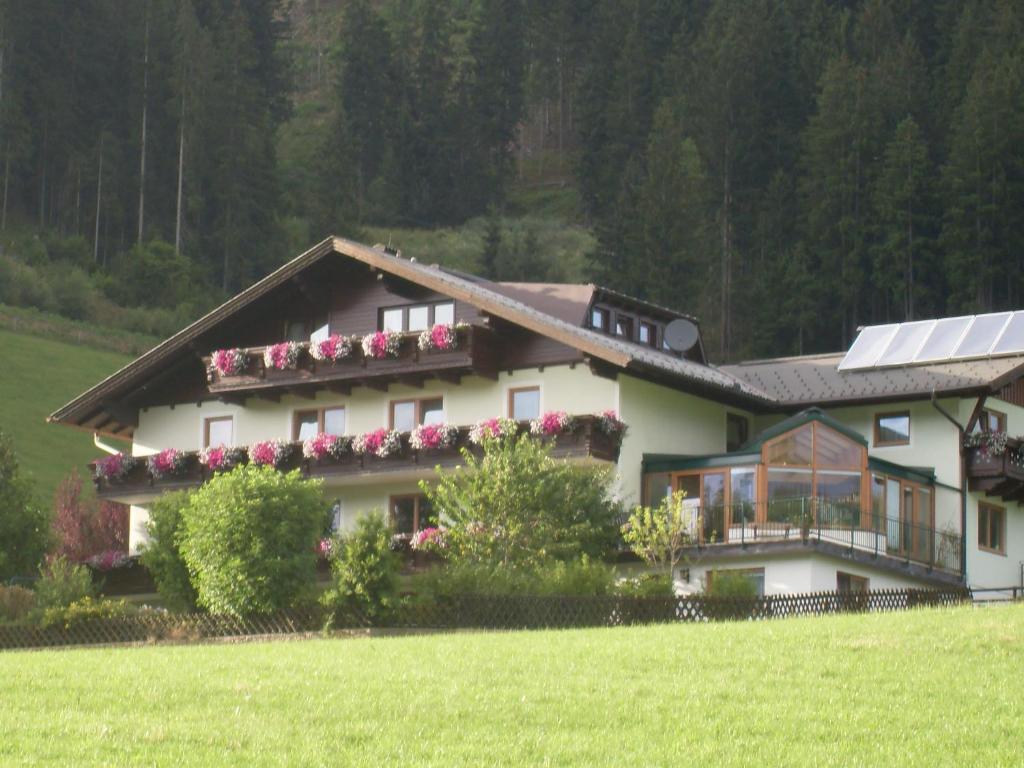 uma casa com flores ao lado dela em Gästehaus Huber Frühstückspension em Schladming