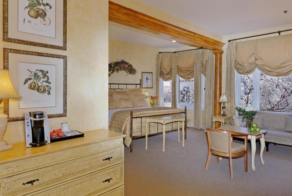 a bedroom with a bed and a table and chairs at Hotel Sausalito in Sausalito