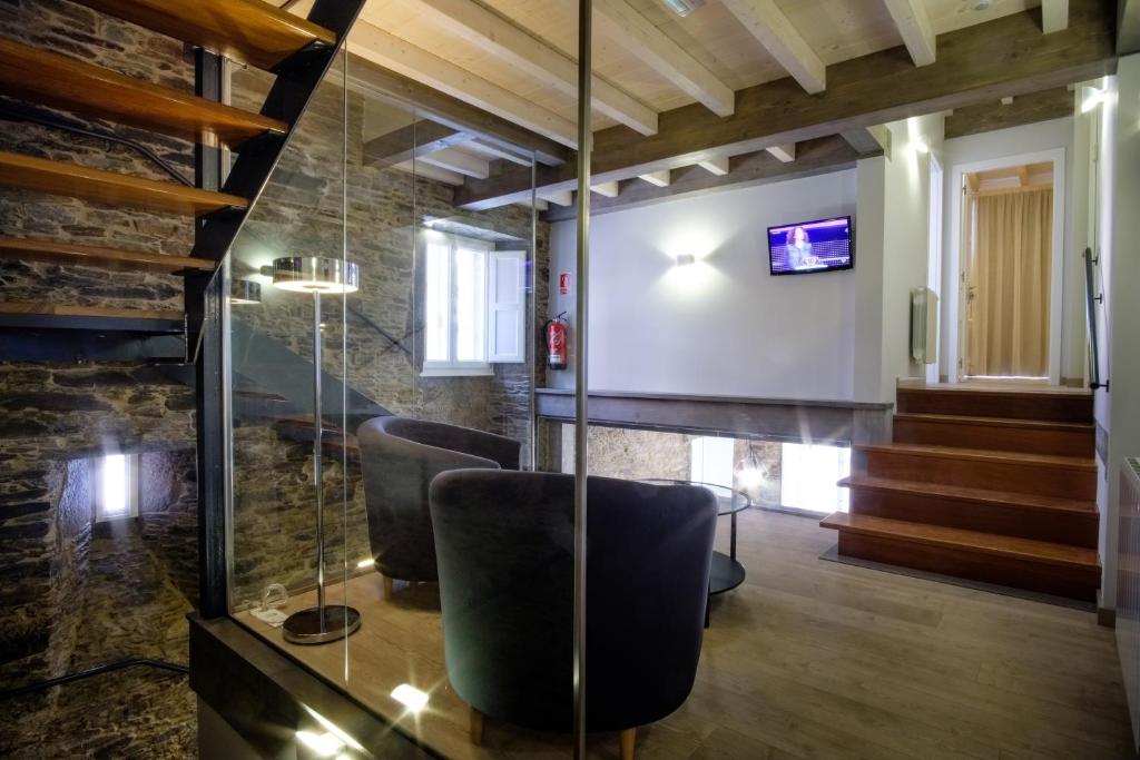 a meeting room with chairs and a tv in a building at Pensión Domus Gallery in Arzúa