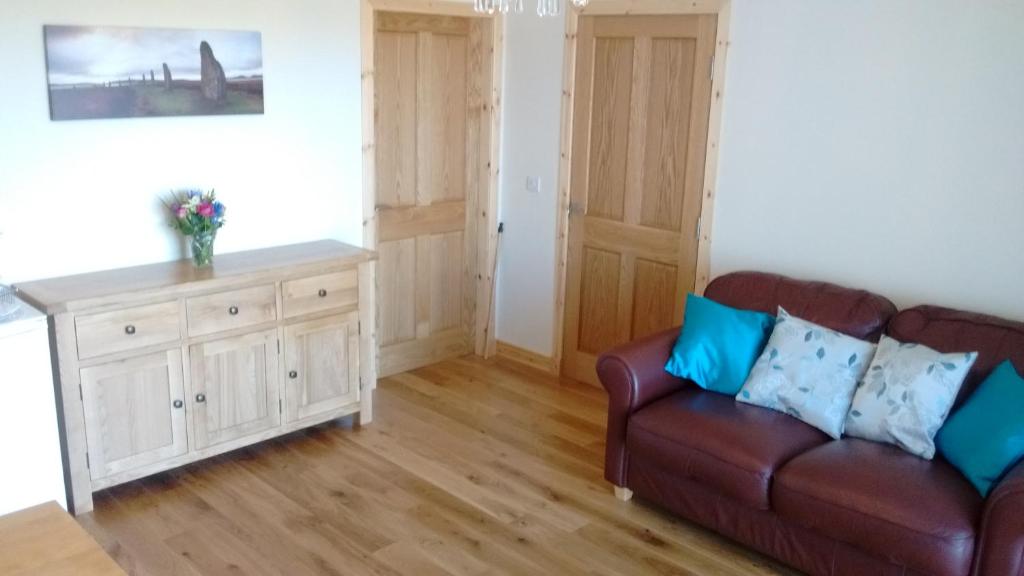 a living room with a couch and a wooden floor at Fara 2 room, 1 bedroom - B&B private suite in Kirkwall