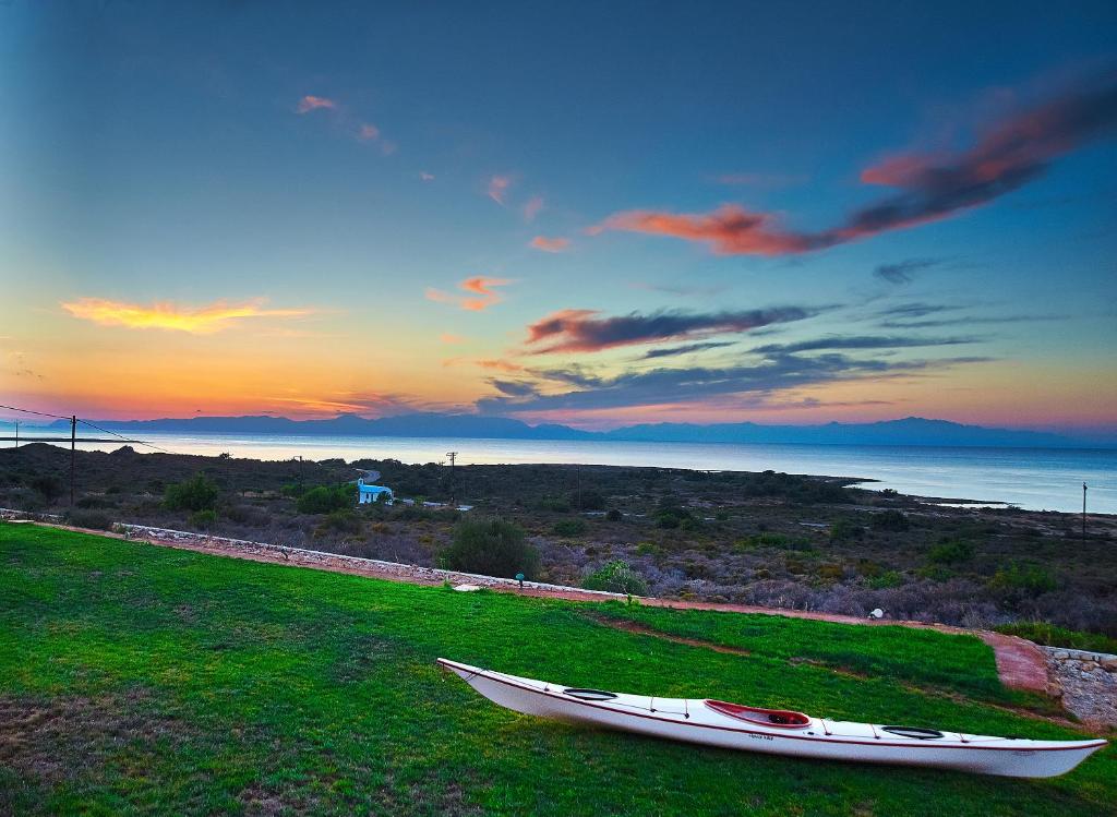 a boat sitting on a grassy field with the sunset at Element Hotel in Elafonisos