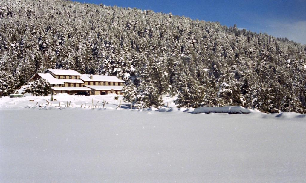 a house in the snow in front of a mountain at Refugi Cap del Rec in Lles