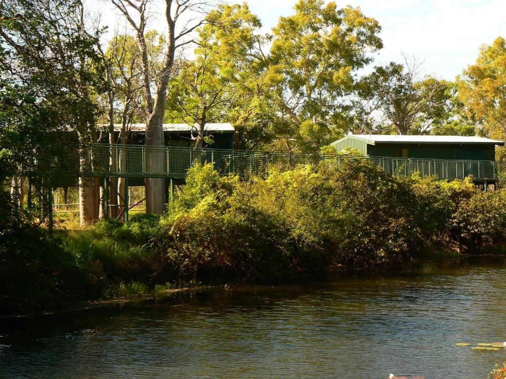 a bridge over a river with a building in the background at Parry Creek Farm Tourist Resort and Caravan Park in Wyndham