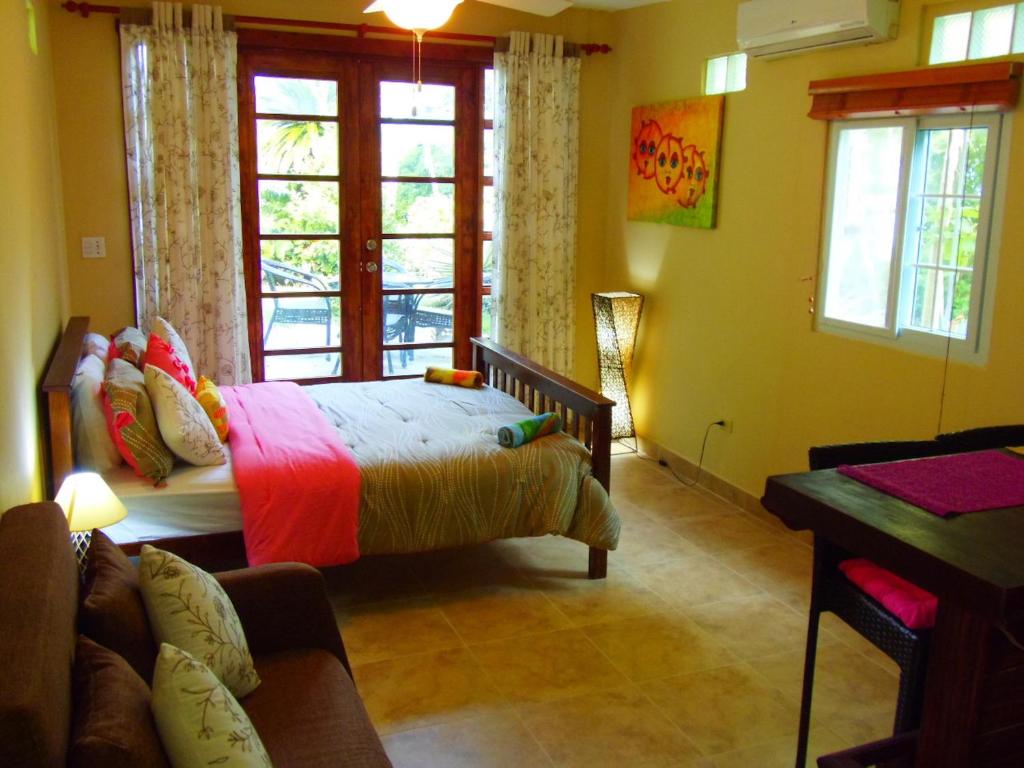 a bedroom with a bed and a couch and windows at Casa del Sol Bed and Breakfast in Contadora