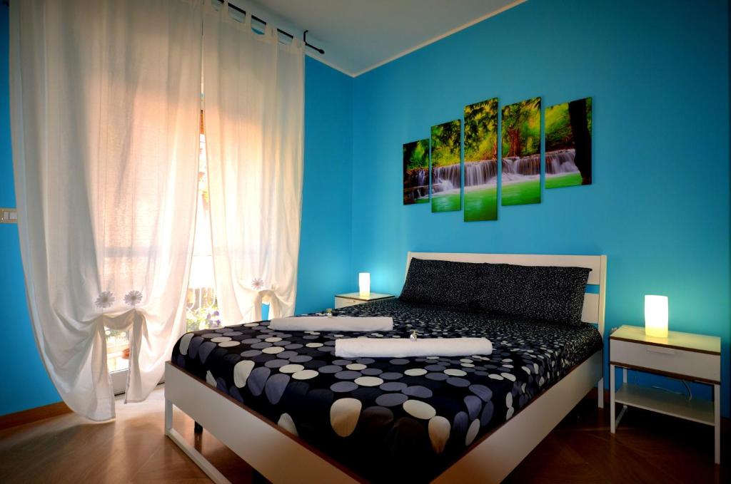 ジャルディーニ・ナクソスにあるNaxos Sea Holiday Apartmentsの青い壁のベッドルーム1室(ベッド1台付)