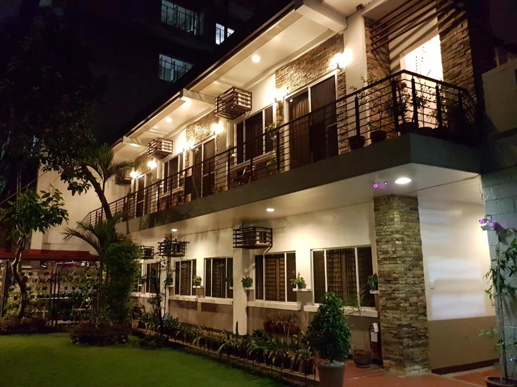 a building with a balcony and a courtyard at night at New Manila Suites in Manila