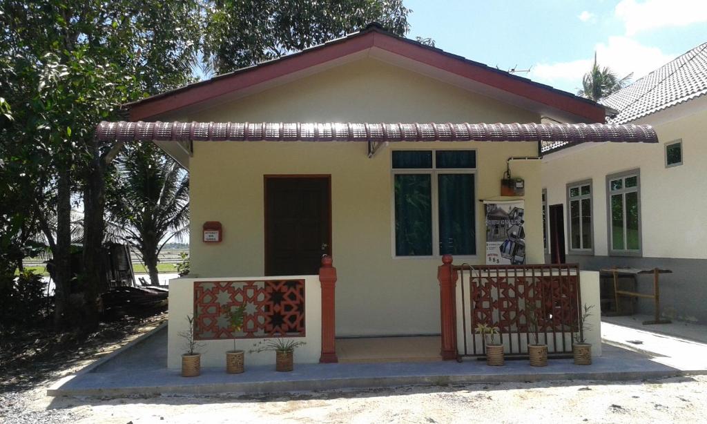 uma pequena casa com um portão em frente em Homestay Kg Paya D Jitra em Jitra
