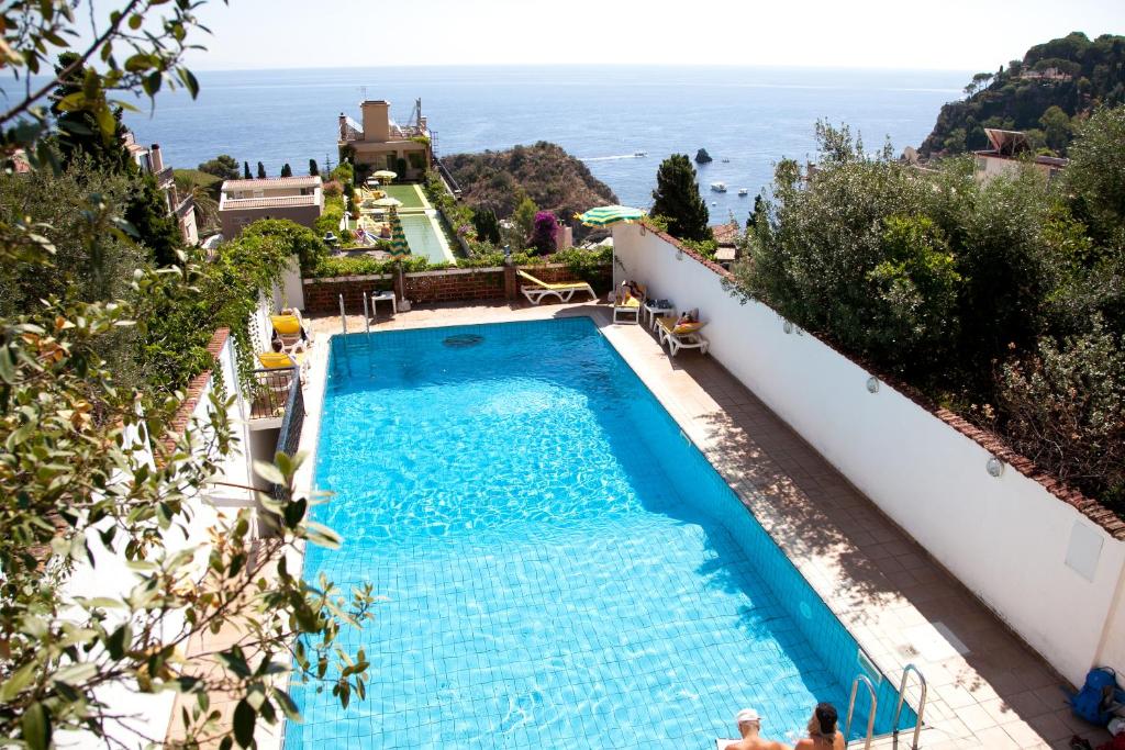 een zwembad met uitzicht op de oceaan bij Hotel Ipanema in Taormina