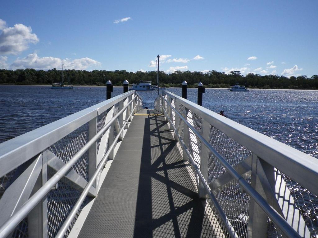 a bridge over a body of water with boats at Tin Can Bay's Sleepy Lagoon Motel in Tin Can Bay
