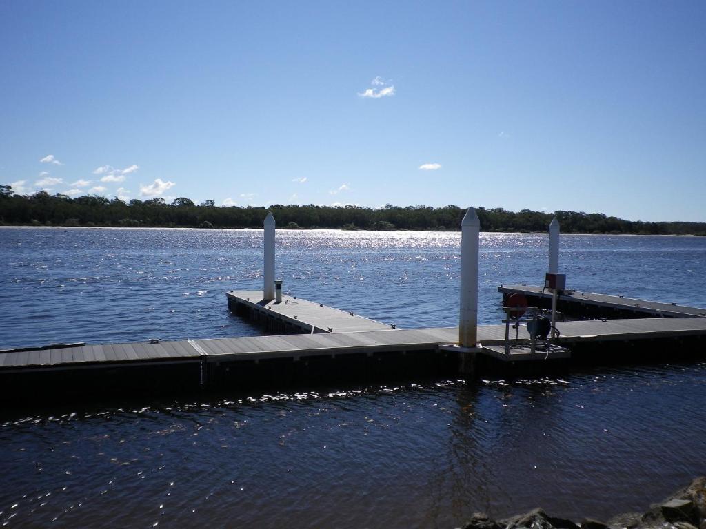 a dock in the middle of a body of water at Tin Can Bay's Sleepy Lagoon Motel in Tin Can Bay