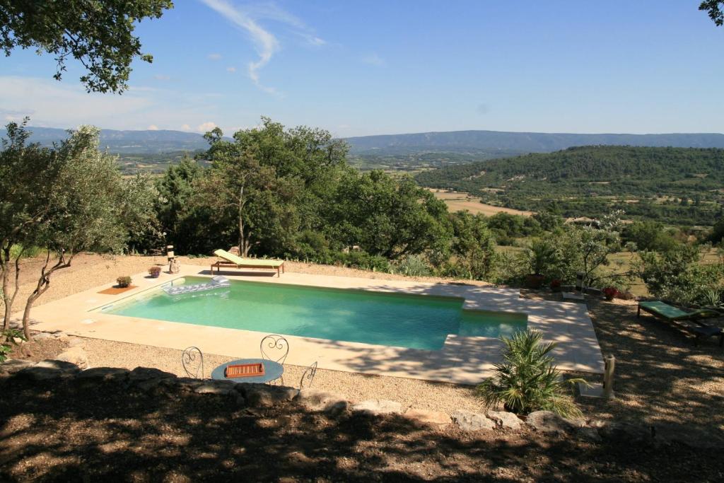 a large swimming pool in the middle of a field at Les Rapieres Mireio in Gordes