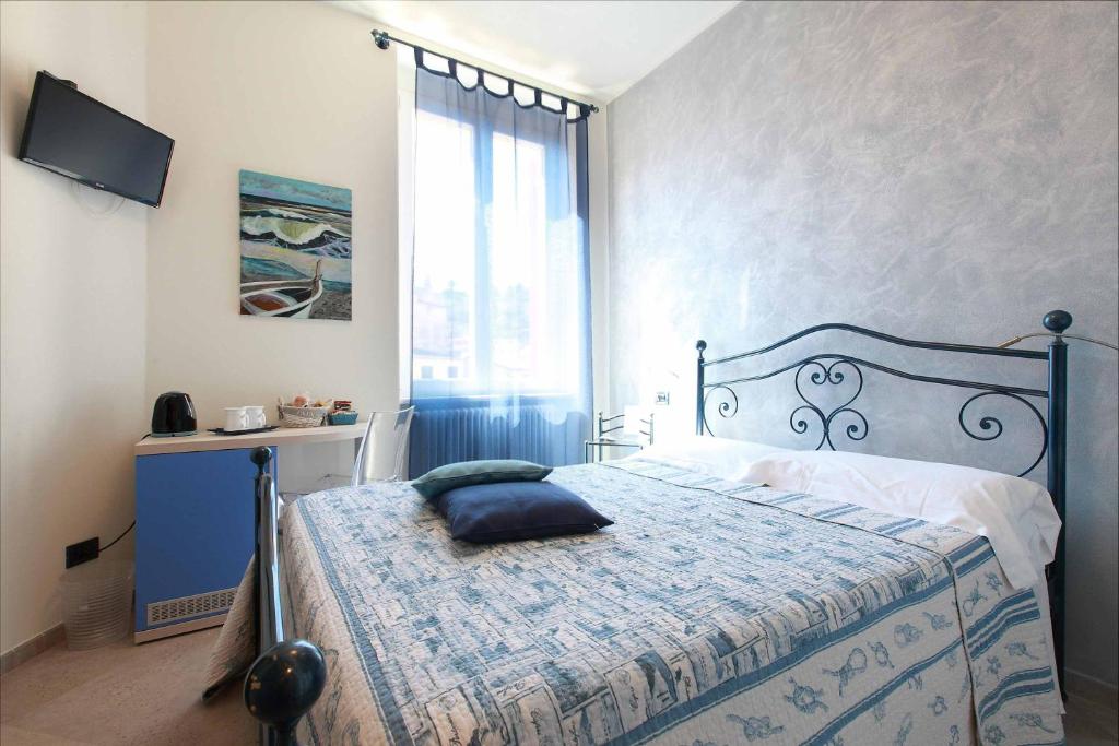 a bedroom with a bed with a blue bedspread and a window at La Rosa Dei Venti in Monterosso al Mare