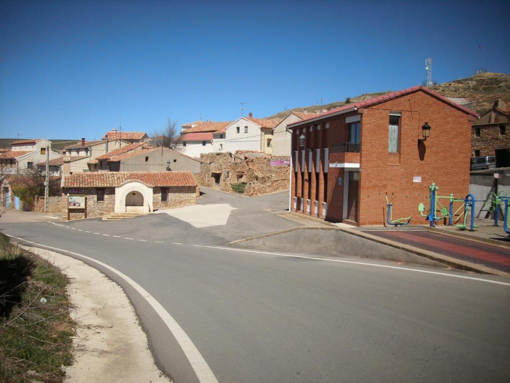 an empty street in a small town with buildings at Antigua escuela in Cañada Vellida