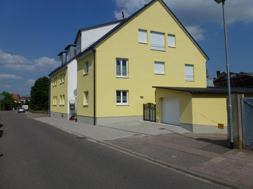 un bâtiment jaune sur le côté d'une rue dans l'établissement Ferienwohnung zur Stadtmauer, à Bad Bergzabern