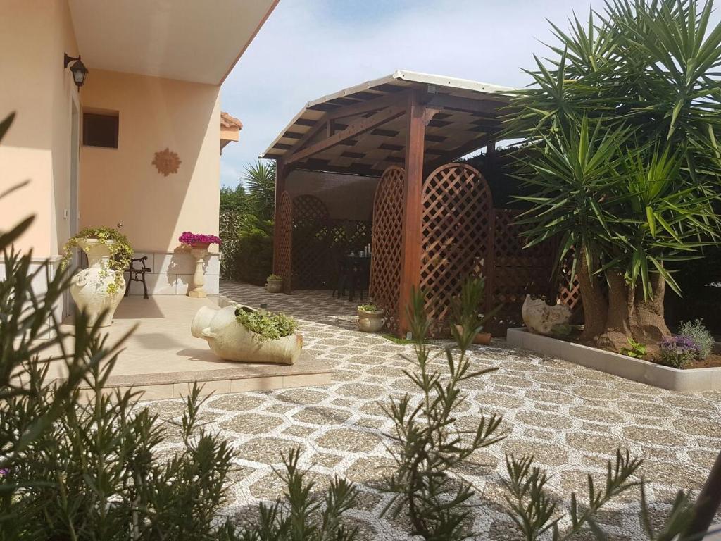 eine Terrasse mit einer Holzpergola und Pflanzen in der Unterkunft B&B L'Oasi del Sole in Uggiano la Chiesa