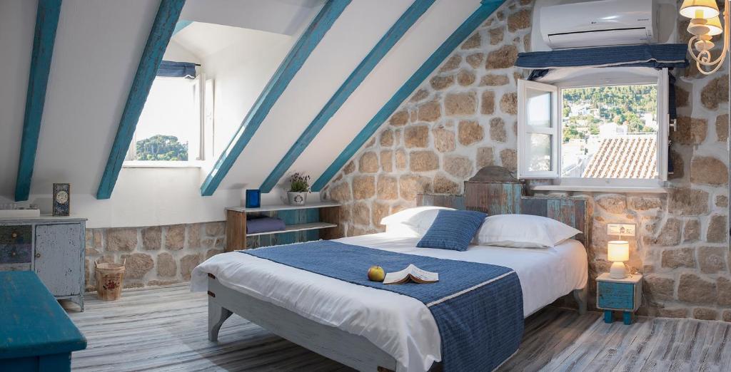 a bedroom with a bed in a room with blue ceilings at Guesthouse Rustico in Dubrovnik