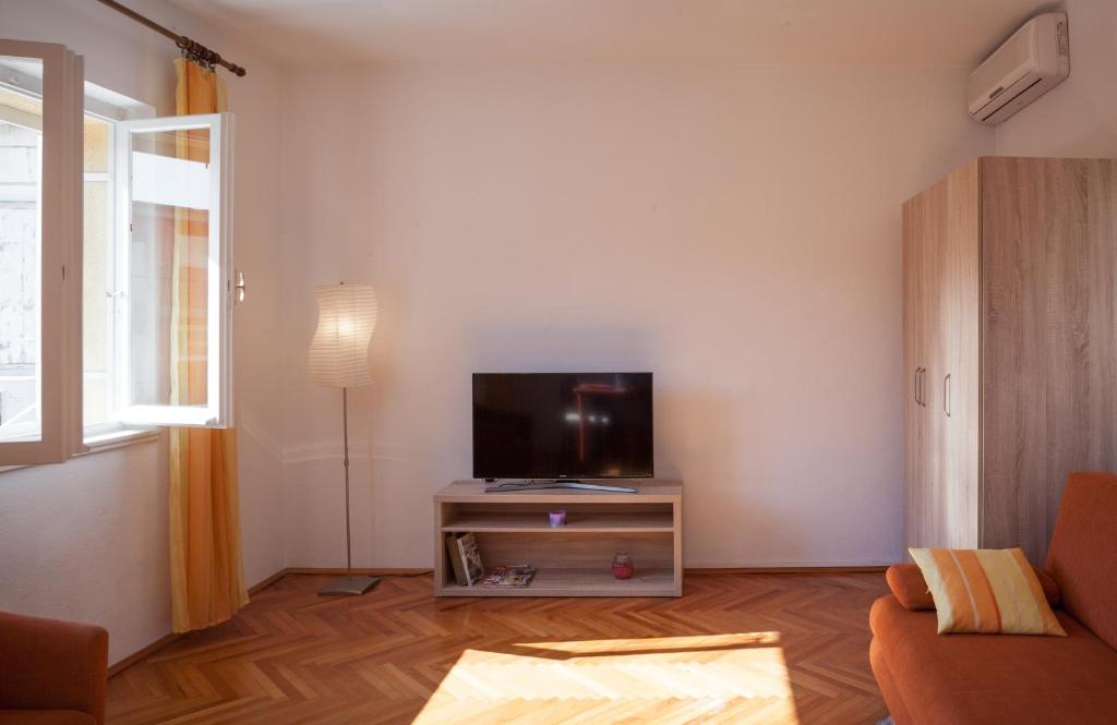 ein Wohnzimmer mit einem Flachbild-TV auf einem Stand in der Unterkunft Apartments Potts Point in Makarska