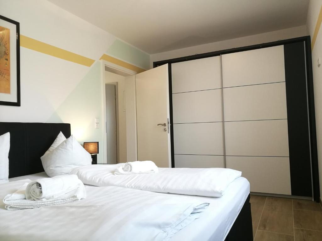 een slaapkamer met 2 bedden met witte lakens en een schuifdeur bij Lucys Haus 1 "am Peeneblick" in Peenemünde