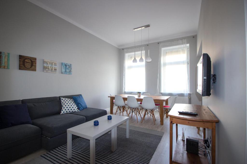 salon z kanapą i stołem w obiekcie Apartament Paderewskiego 11 w Świnoujściu