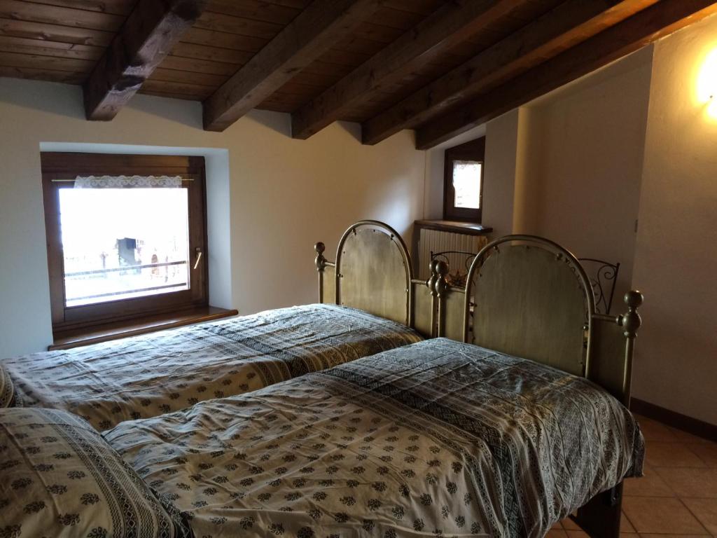 a bedroom with two beds and a window at Casa Nadia in San Zeno di Montagna
