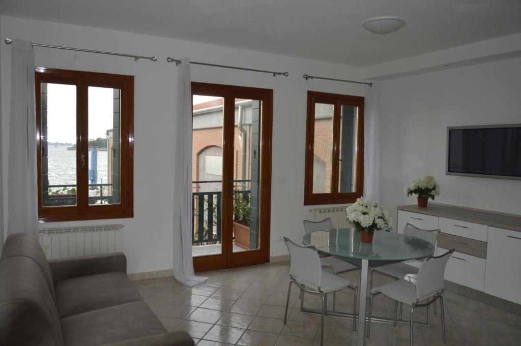 sala de estar con mesa de cristal y sillas en Calle Michelangelo Apartments en Venecia