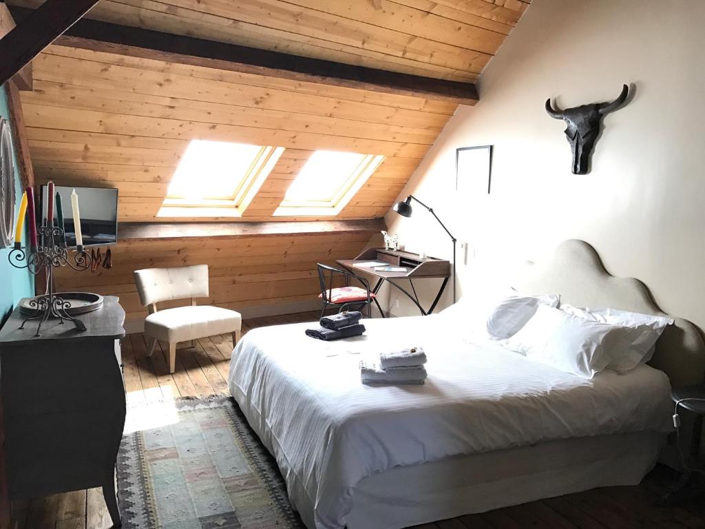 1 dormitorio con cama, silla y escritorio en Maison l'épicurienne, en Les Sables-dʼOlonne