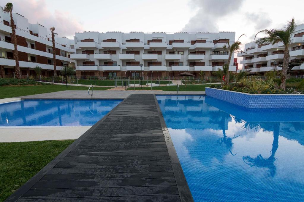 a swimming pool in front of a large apartment building at Cabo Roig Terrazas de Campoamor 25 in Playas de Orihuela