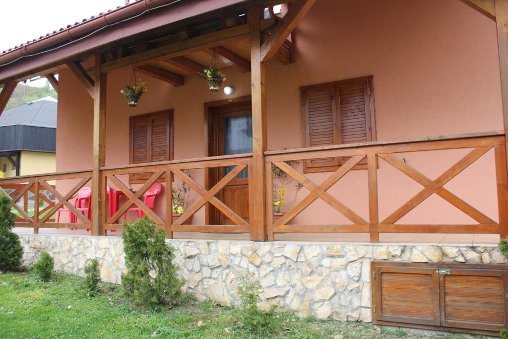 ein Haus mit Holztüren und einer Steinmauer in der Unterkunft Apartmany u Janka Vinné Jazero in Vinné